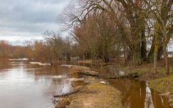 Flooded river bank during spring floods. Melting pieces of ice and broken tree branches brought ashore by the stream. Gauja. Latvia