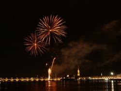 Fireworks in Bordeaux: golden fireworks explosions over the Garonne river in Bordeaux old city at night, France 2019