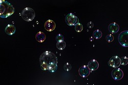 Beautiful soap bubbles colorful float on dark background