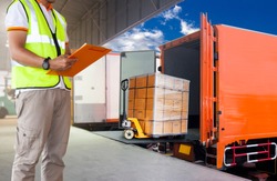 warehouse and logistics, freight transportation. courier shipment transportation. worker man in uniform is checking load the shipment transport by truck.