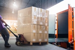 Worker Courier Unloading Package Box Out Of Cargo Container. Delivery service. Truck Loading at Dock Warehouse. Supply Chain. Shipments. Shipping Warehouse Logistics and Transportation.	