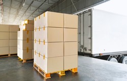 Packaging Boxes Stacked on Pallets Load with Shipping Cargo Container. Delivery Trucks Loading at Dock Warehouse. Supply Chain. Shipment Boxes. Distribution Warehouse Freight Truck Transport Logistics