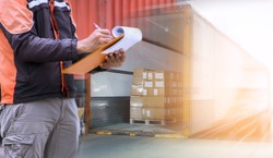 Worker Holds a Clipboard Checking the Loading Cargo Shipment at Distribution Warehouse. Forklift Loading Delivery to Customers. Package Boxes Supplies Warehouse. Freight Truck Logistics Transport 