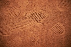 footprints on a clay tennis court close-up. Footprints on a clay tennis court. Footprints on a clay tennis court. Footprint on a tennis court bright color. Background for sport design, wallpaper.