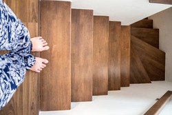 Women in casual wearing walks down the stair in her home.