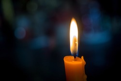 One light candle burning brightly with bokeh background