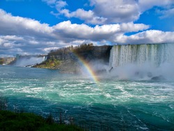 Breathtaking view of Niagara Waterfall in Toronto Canada with clouds on top, Waterfall, Rainbow, reflection of sun in the water.