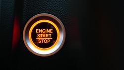 Car dashboard with focus on red engine start stop button, car interior details. button engine start and engine stop, Car engine push start stop button ignition remote starter.