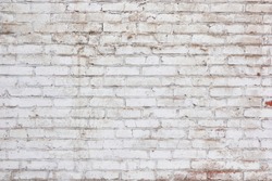 Whitewashed vintage brick wall. Background of stained horizontal brick masonry exterior wall of a rural building.