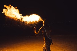 fire show, dancing with flame, male master fakir with fire works, performance outdoors, flame control man, a man in a suit LED dances with fire, draws a fiery figure in the dark