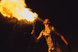 fire show, dancing with flame, male master fakir with fire works, performance outdoors, flame control man, a man in a suit LED dances with fire, draws a fiery figure in the dark