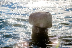 A stone sculpture stands in seawater