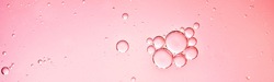 oil with bubbles on coral background. Pink Abstract space background. Soft selective focus. macro of oil drops on water surface. copy space. air bubbles in water, Banner format