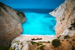 Shipwreck in Navagio beach. Azure turquoise sea water and paradise sandy beach. Famous tourist visiting landmark on Zakynthos island, Greece