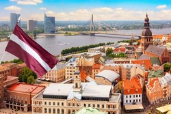 Panoramic view of the old city of Riga, Latvia from the tower Church of St. Peter with Latvia flag. Summer sunny day.