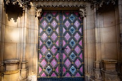 Purple cathedral doors with ornaments in Prague, Czech Republic