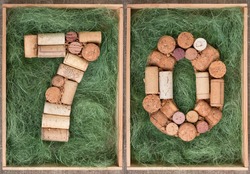 Number 70 seventy  made of wine corks on green background in wooden box