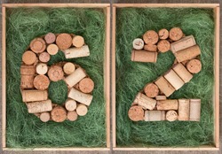 Number 62  sixty two  made of wine corks on green background in wooden box