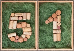 Number fifty one  made of wine corks on green background in wooden box