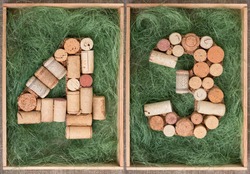 Number 43 forty three  made of wine corks on green background in wooden box