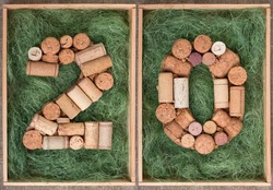 Number 20 twenty  made of wine corks on green background in wooden box