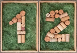 Number 12  twelve made of wine corks on green background in wooden box