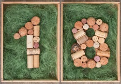 Number 18 eighteen made of wine corks on green background in wooden box