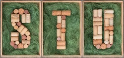 Alphabet letter S T U  made of  wine corks on green background in wooden box. ABC set  