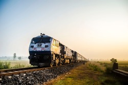 indian railway train on paddy fields 