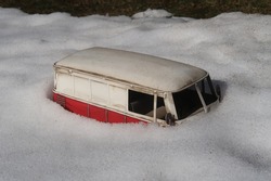 Toy car buried in the snow. Winter season. 