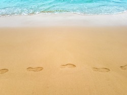Footprints in sand on sea coast. Print on beach top view