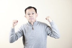 Middle-aged Japanese man in gray turtleneck wool sweater under white background. Concept image of Warm Biz, stability in daily life, and sustainable living.