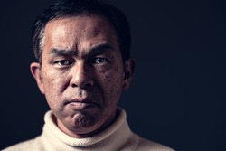 Middle-aged Asian man in white turtleneck wool sweater under black background. Concept image of Warm Biz, stability in daily life, and sustainable living.