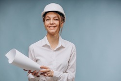 Business woman wearing safety hat and holding papers