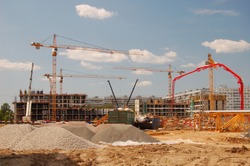 Construction cranes on a blue sky background