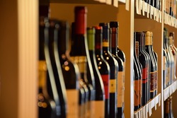 Wine bottles on wooden shelf in wine store