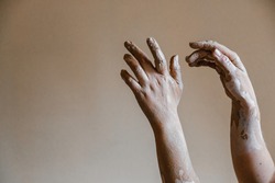 Hands of ceramist are smeared with clay after she sculpted pottery