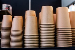 Lot of drinking paper coffee cups in piles. Stack of disposable coffee cup, selective focus