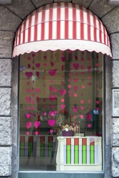 Retro window with red striped canopy. Showcase candy store. Glass in sweets store