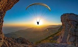 Paragliding concept, paraglider pilot fly in sky on beauty nature mountain landscape Crimea background, horizontal photo