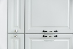 Close up detail of vintage white cabinet, original ceramic handles, selective focus, copy space