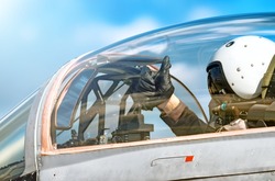 Modern military fighter jet aircraft canopy exterior close up silhouette view pilot waving OK gesture inside cockpit interior airplane parts sky glass reflection aviation aerial panoramic background