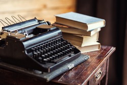 vintage typewriter and books on the table with blank paper on wooden desk
