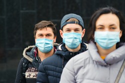 Coronavirus epidemic. People wearing face mask outdoors. Group of young volunteers. Coronavirus quarantine. Global pandemic. Worldwide coronavirus outbreak.