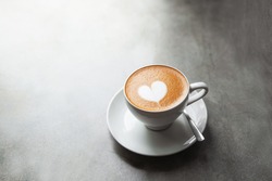 White cup of tasty cappucino with love art latte. Valentine's day concept. Concrete grey backdrop. Copy space