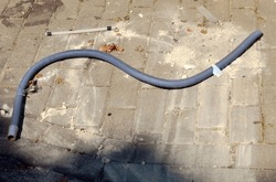 A plastic pipe for draining water from household and industrial appliances thrown around a garbage can