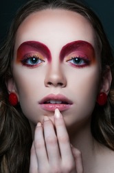 fashion beauty portrait of model with modern vogue trendy make up, magazine editorial ready, close up red eye shadows and lipstick, n studio 