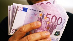 a rich man shows 10,000 euros in many 500 euro notes. Concept of wealth and richness
