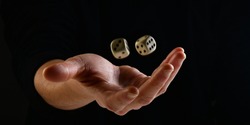 Female hand throwing two white dice in the air on black background. Game with dice, Hazard, Cho-Han Bakuchi, Under-Over 7, Mexico, Shut the Box. Gambling luck concept: bet, risk, have luck, win. lucky