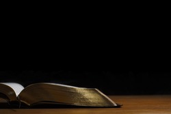 Golden bible on black background